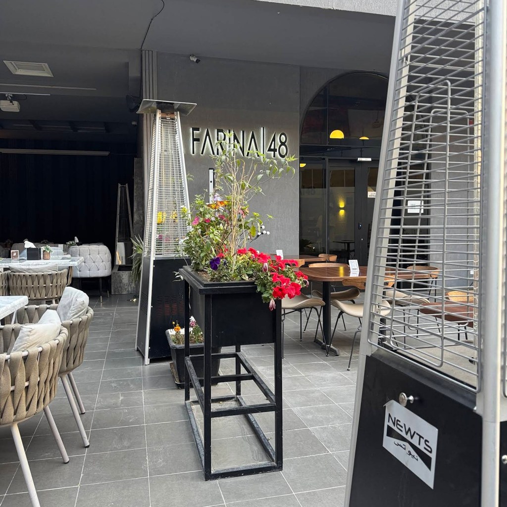 مدخل مطعم لاروز لاونج في الرياض مع أجواء عصرية، يتضمن منطقة خارجية مزودة بمقاعد وكراسي مريحة وزهور ملونة.